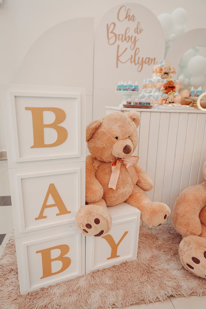 Services Charming baby shower decor featuring a large teddy bear and alphabet blocks spelling 'BABY'.