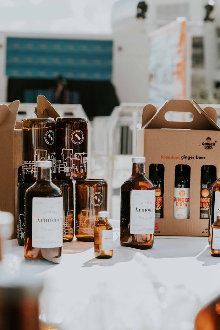 A variety of bottles and ginger beer packs on a table, captured outdoors in bright daylight.