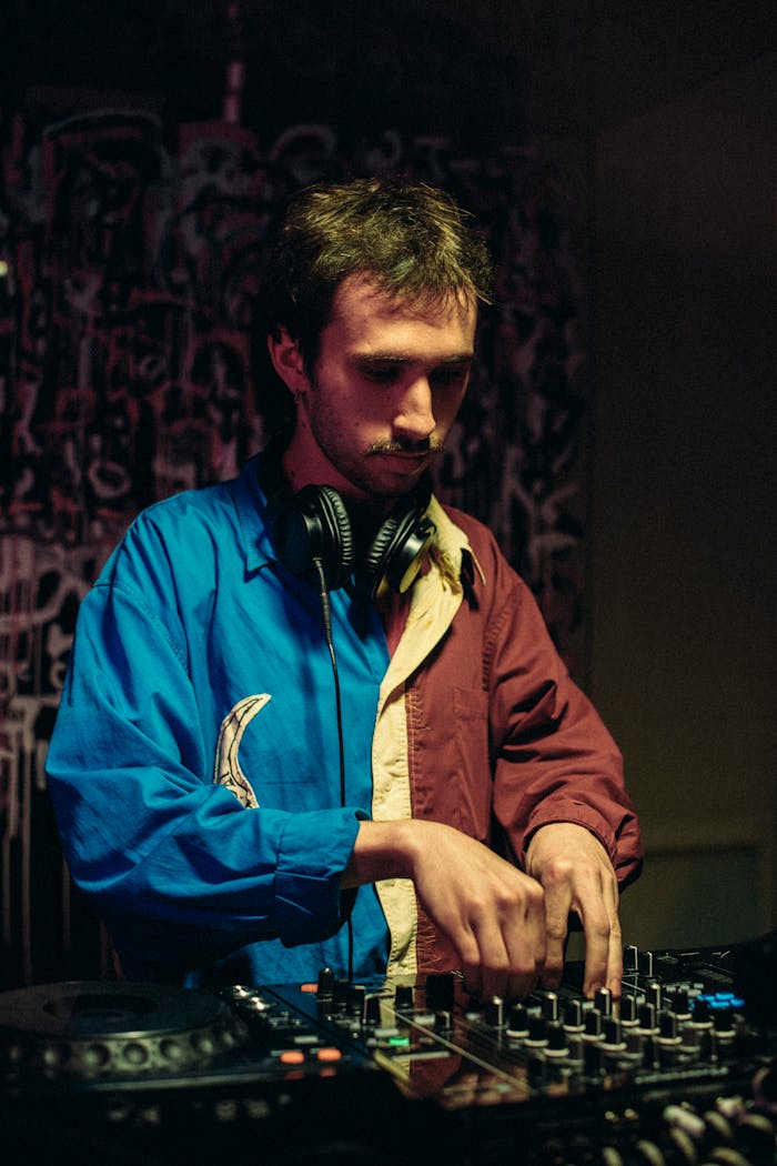About A DJ wearing headphones works with a sound mixer at an indoor venue in Lviv, Ukraine.