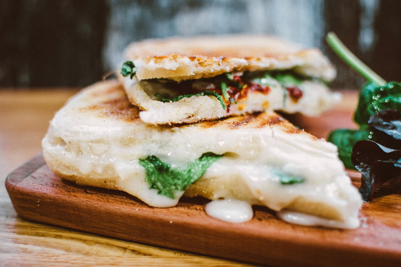 Services Delicious grilled panini loaded with melted cheese and fresh spinach, perfect for a satisfying meal.